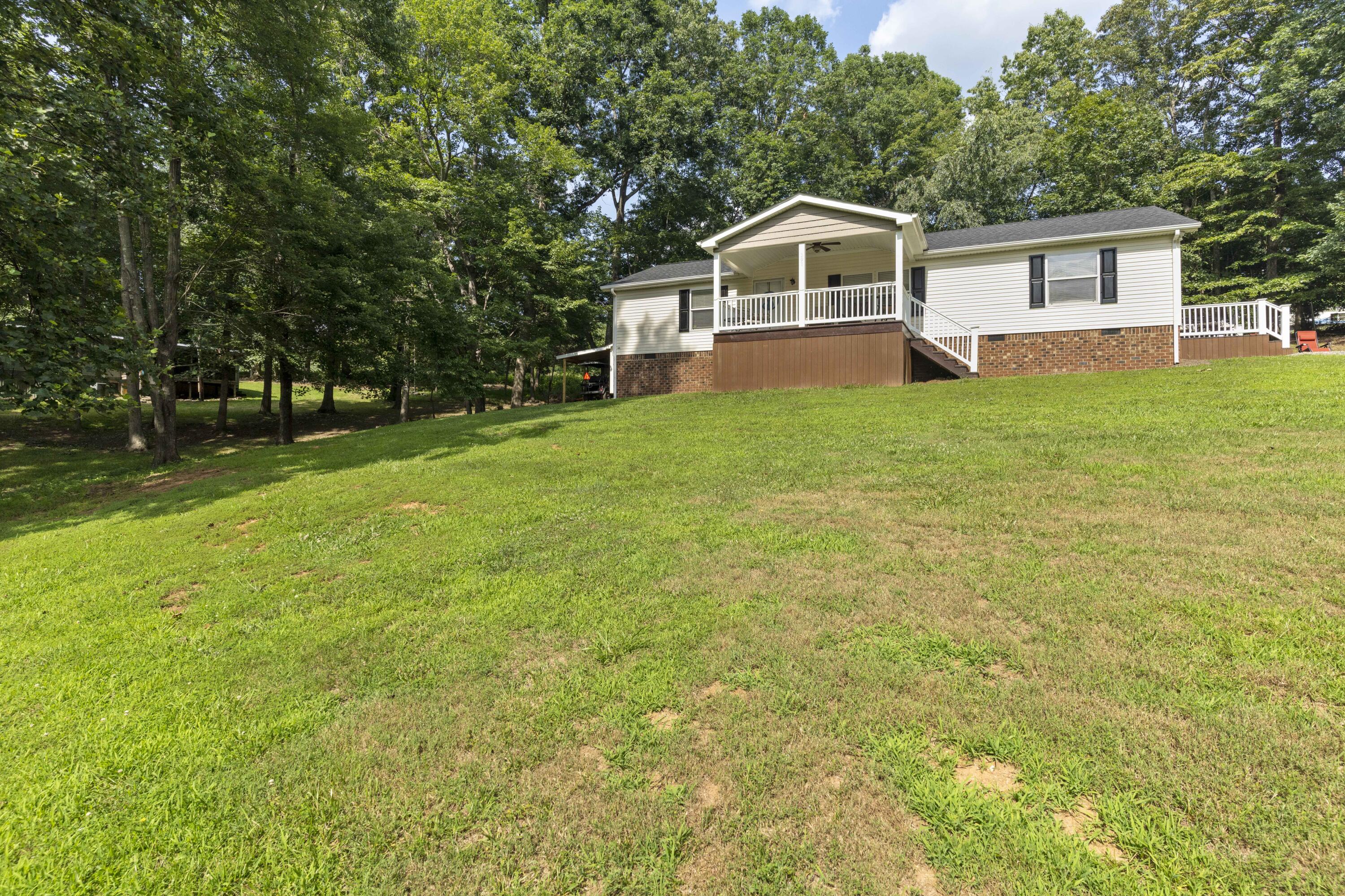 391 Cool Branch Road Penhook, VA 24137 - Photo 10 of 54 a front view of a house with yard and green space