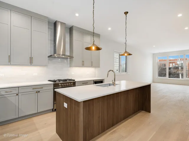 a kitchen with a sink a stove a refrigerator and wooden floor