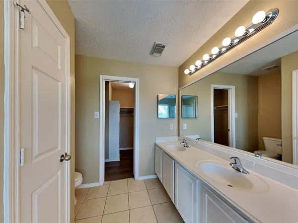 a large bathroom with a double vanity sink and a mirror