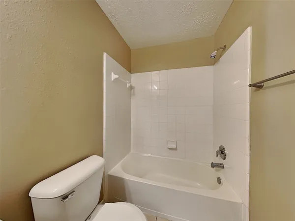 a white toilet sitting next to a bath tub