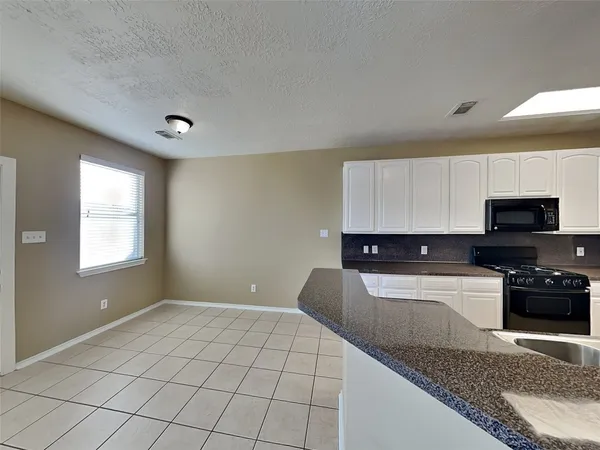 a kitchen with a sink a stove and cabinets