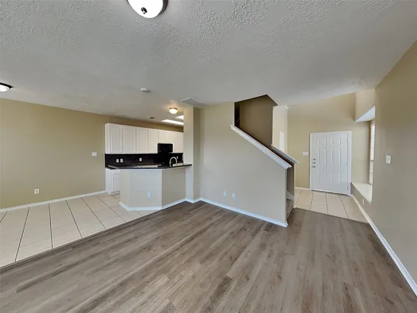 a view of a kitchen with wooden floor and electronic appliances