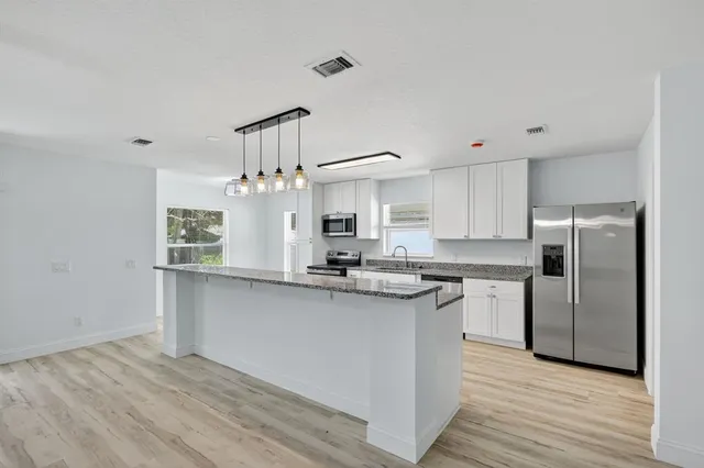 a kitchen with stainless steel appliances granite countertop a sink stove and refrigerator