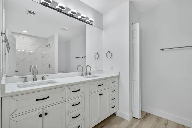 a bathroom with a double vanity sink double and mirror