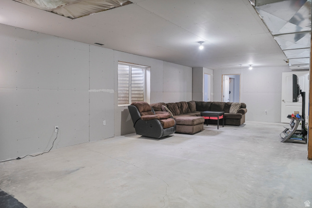 860 West 2980th Street South Logan, UT 84321 - Photo 34 of 38 Lower level space featuring unfinished drywall, exposed ceiling joists with insulation, a single window, and concrete flooring