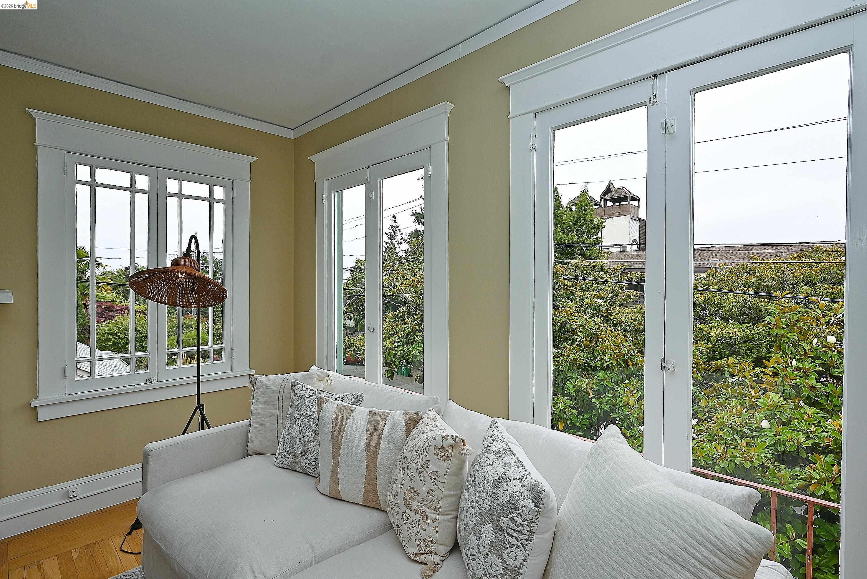 1301 Bonita Avenue, Unit 3 Berkeley, CA 94709 - Photo 12 of 48 Light-filled interior featuring multiple windows with white trim, crown molding, and hardwood floors.