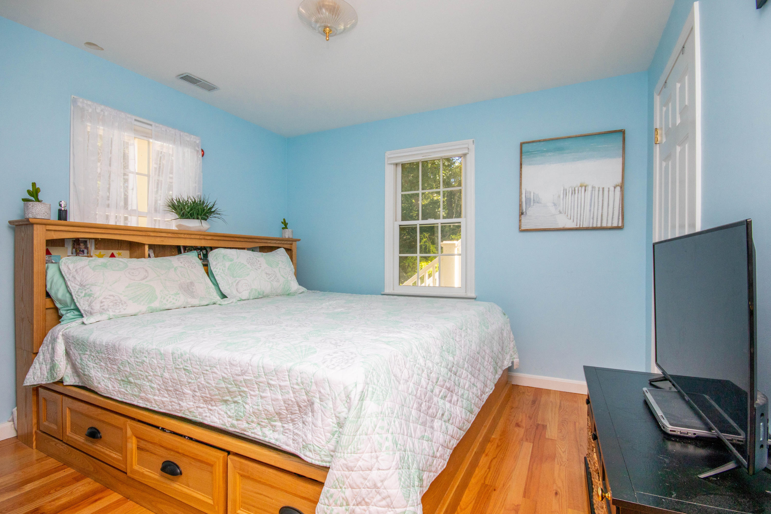 52 Lovells Road Cotuit, MA 02635 - Photo 27 of 51 a bedroom with a bed and a flat tv screen on dresser