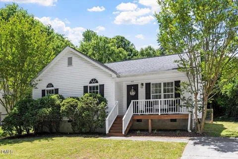 a view of house with swimming pool and trees in the background
