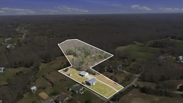 a aerial view of a house with a yard table and chairs