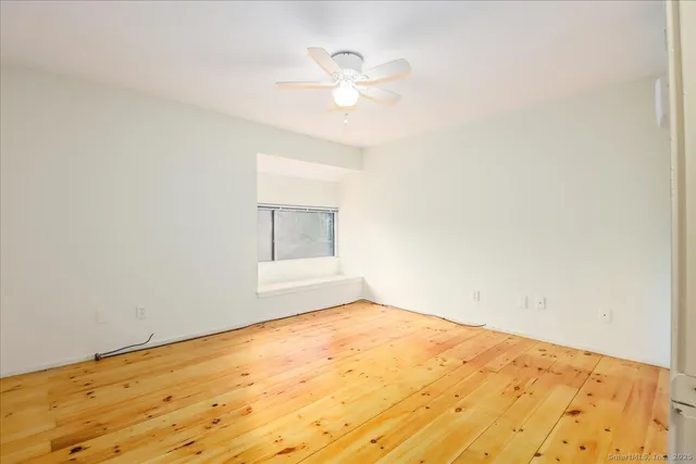 a view of empty room with wooden floor
