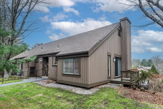 a view of backyard with a barn and a large tree