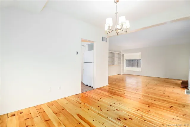 a view of a bedroom with wooden floor and chandelier