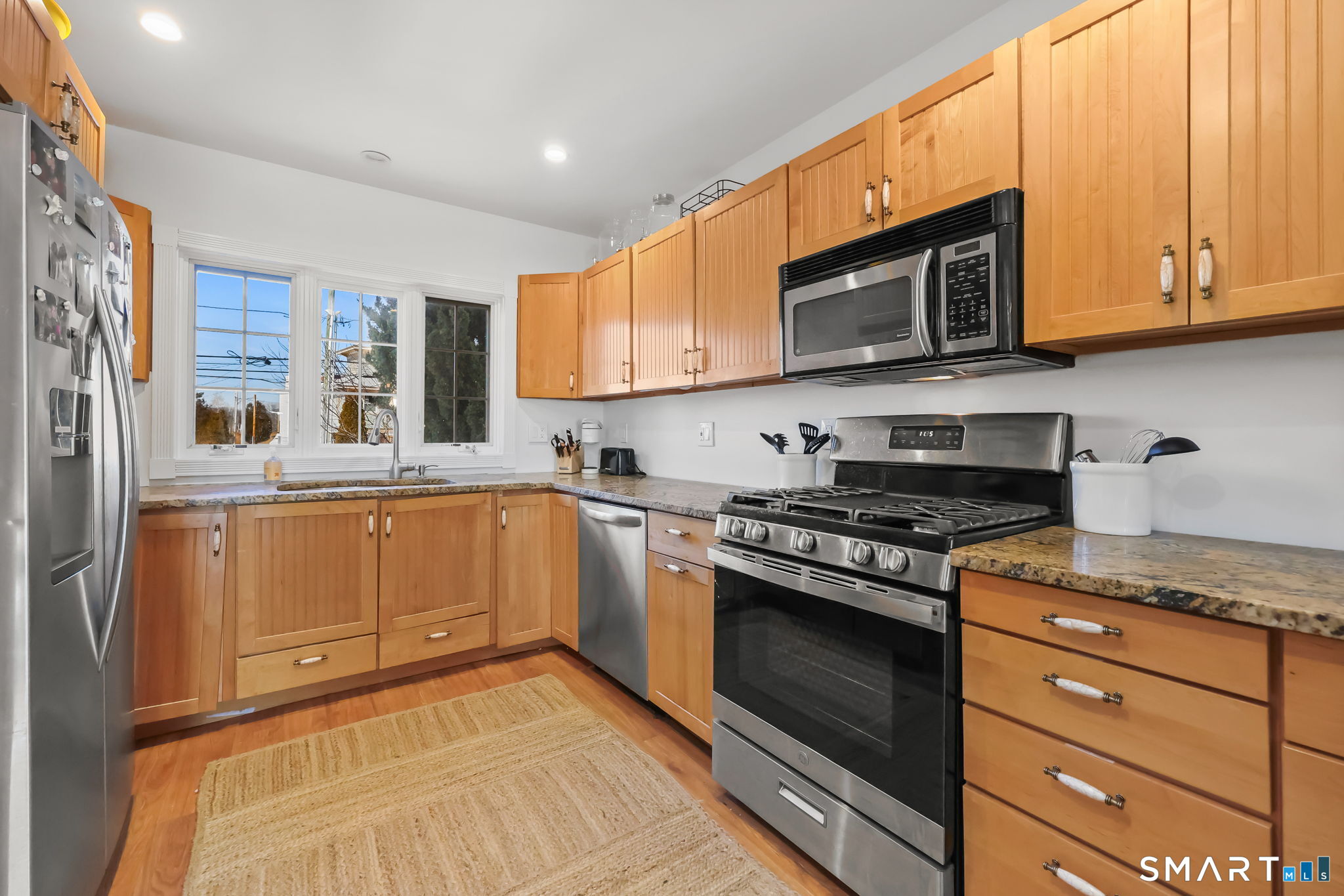 a kitchen with stainless steel appliances granite countertop a stove a sink and a microwave