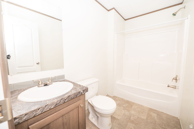 2491 Highway 89, Unit 403 Pleasant View, UT 84404 - Photo 25 of 32 Bathroom featuring a wood-finish vanity with a stone-look countertop, an oval undermount sink, and a brushed nickel faucet