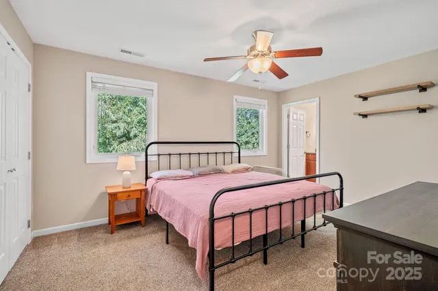 a bedroom with a bed a chandelier and a window