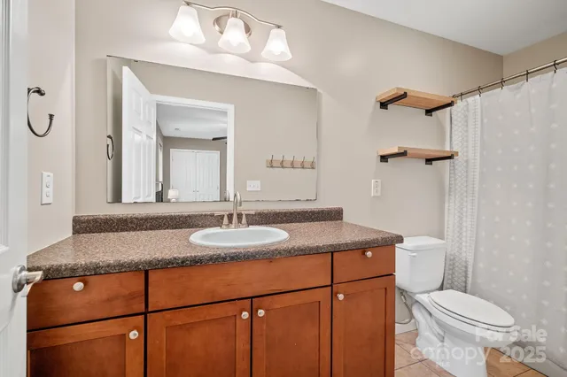 a bathroom with a granite countertop sink toilet a mirror and shower