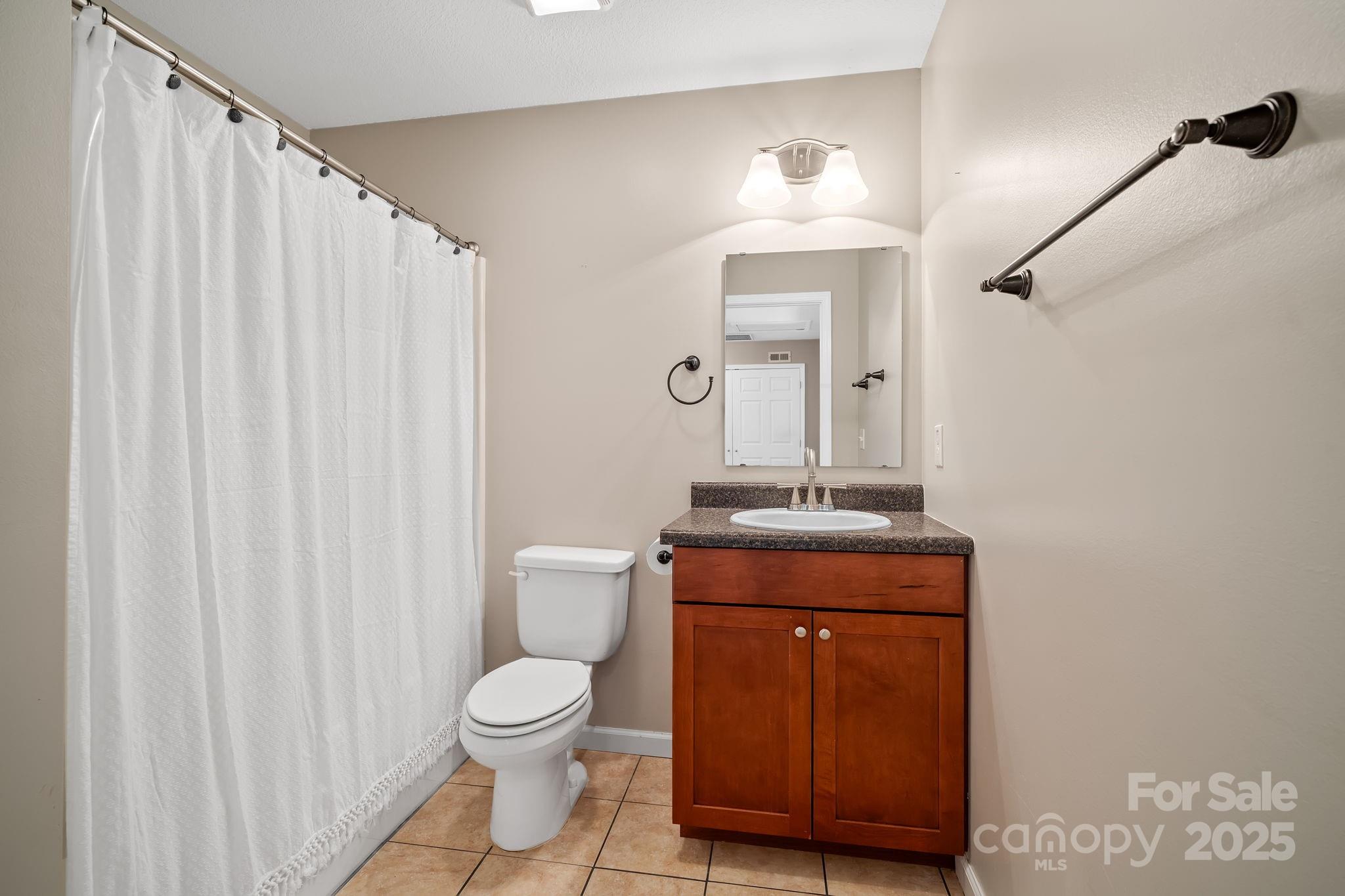 33 English Ivy Road Asheville, NC 28806 - Photo 21 of 27 a bathroom with a granite countertop toilet a sink and a mirror