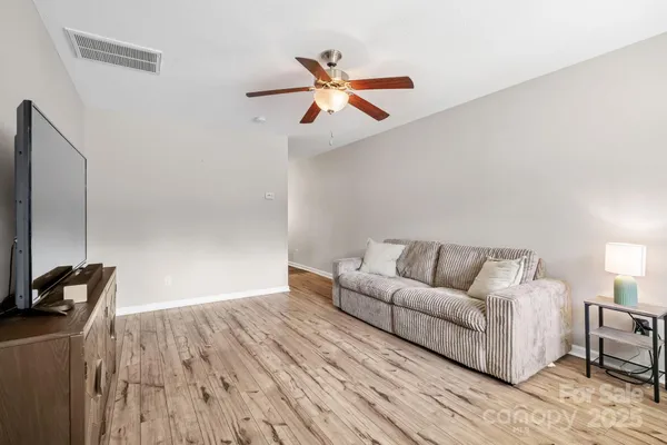 a living room with furniture and a ceiling fan