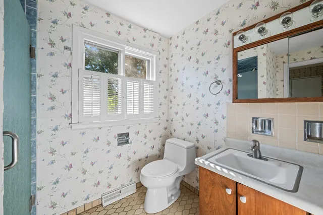 a bathroom with a granite countertop sink toilet and mirror
