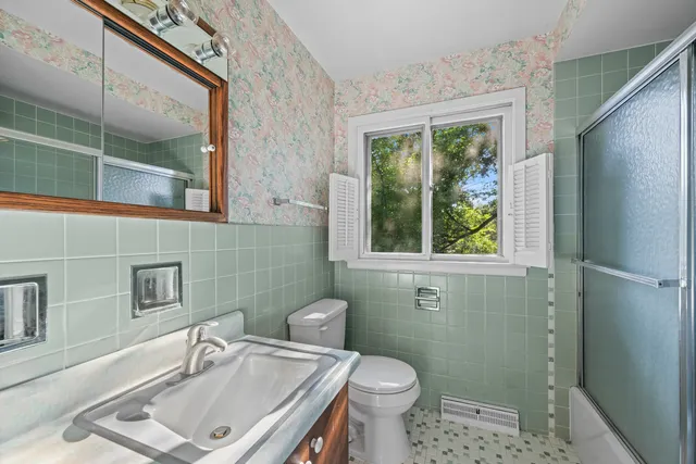 a bathroom with a sink a toilet and a mirror