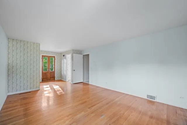a view of an empty room with wooden floor