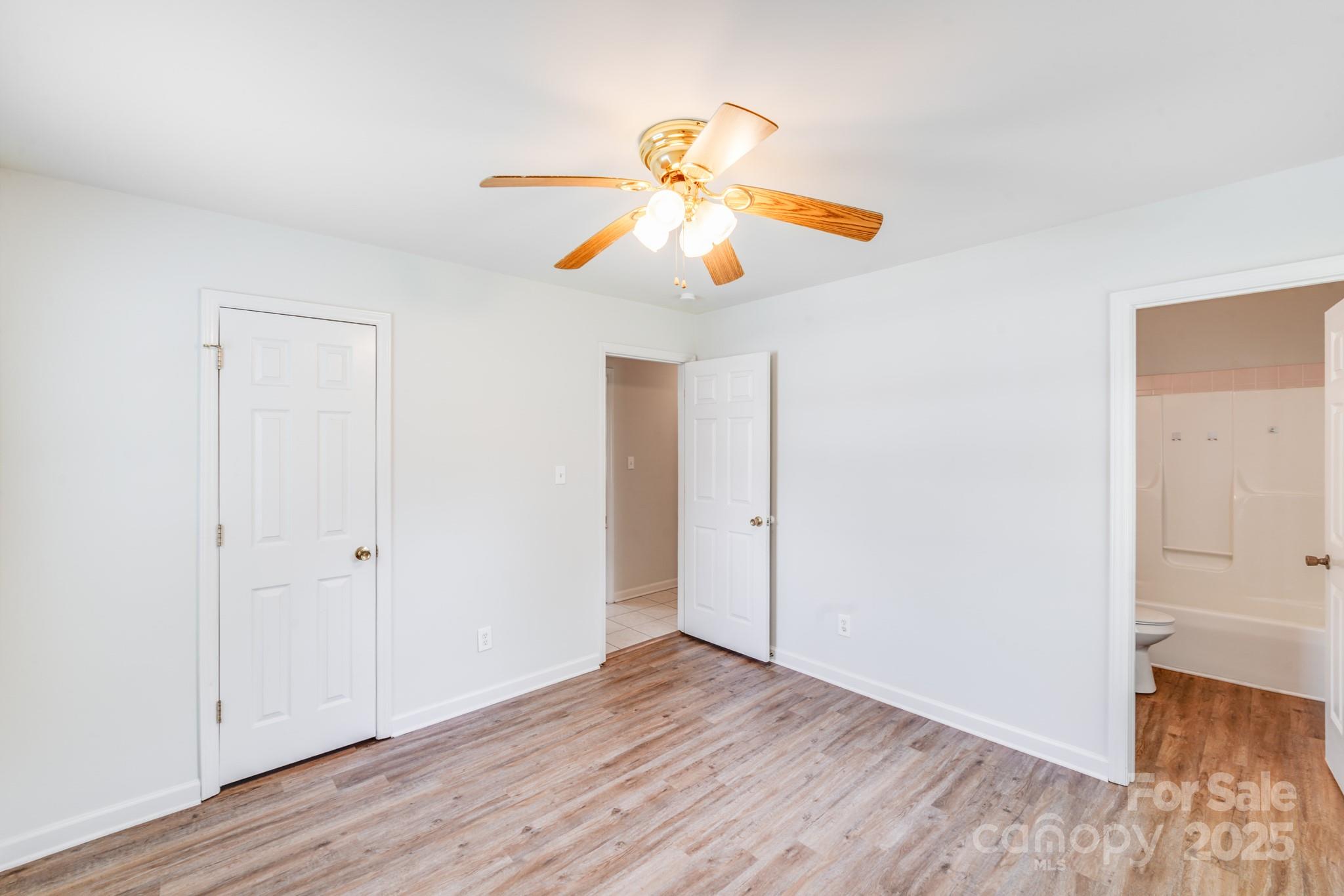 8905 Moores Chapel Road Charlotte, NC 28214 - Photo 13 of 22 an empty room with wooden floor ceiling fan and window