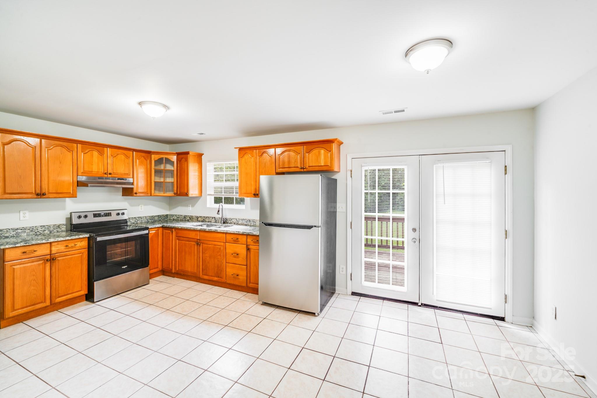 8905 Moores Chapel Road Charlotte, NC 28214 - Photo 4 of 22 a kitchen with stainless steel appliances granite countertop a refrigerator a sink a stove a washer dryer and next to a window