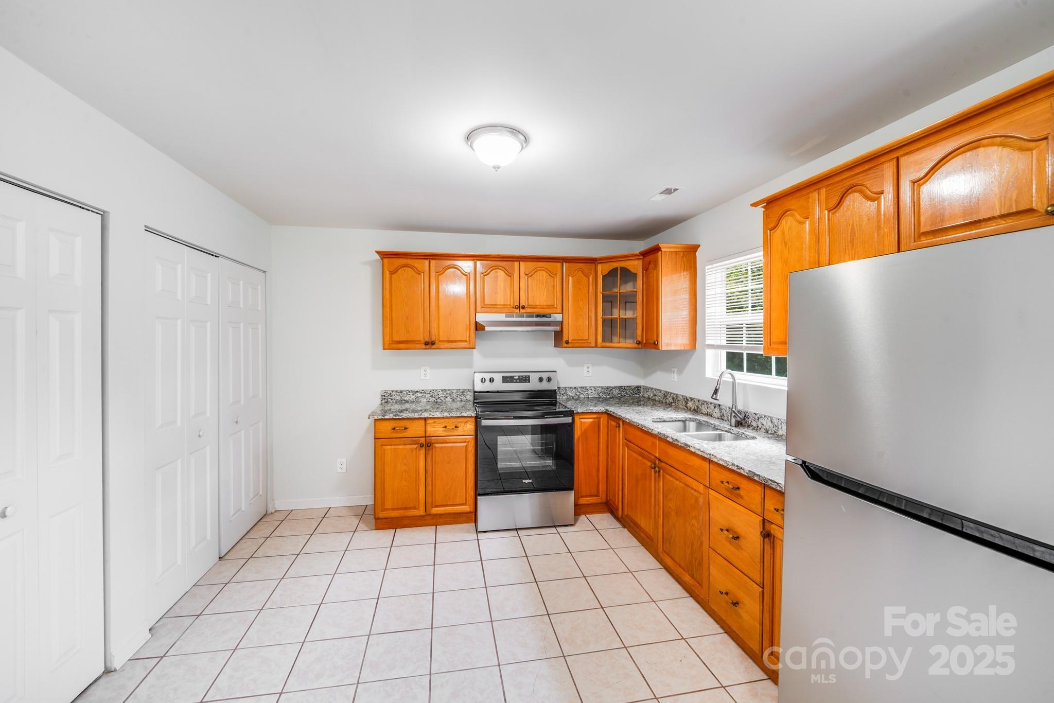 8905 Moores Chapel Road Charlotte, NC 28214 - Photo 9 of 22 a kitchen with stainless steel appliances granite countertop a refrigerator a sink dishwasher and wooden cabinets