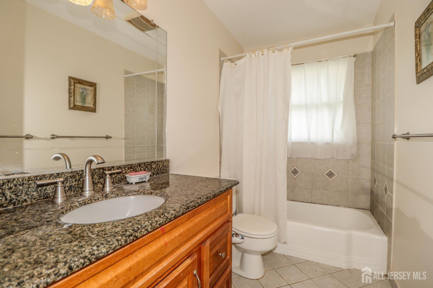 5 Timothy Court Edison, NJ 08837 - Photo 21 of 32 a bathroom with a granite countertop sink a toilet and bathtub
