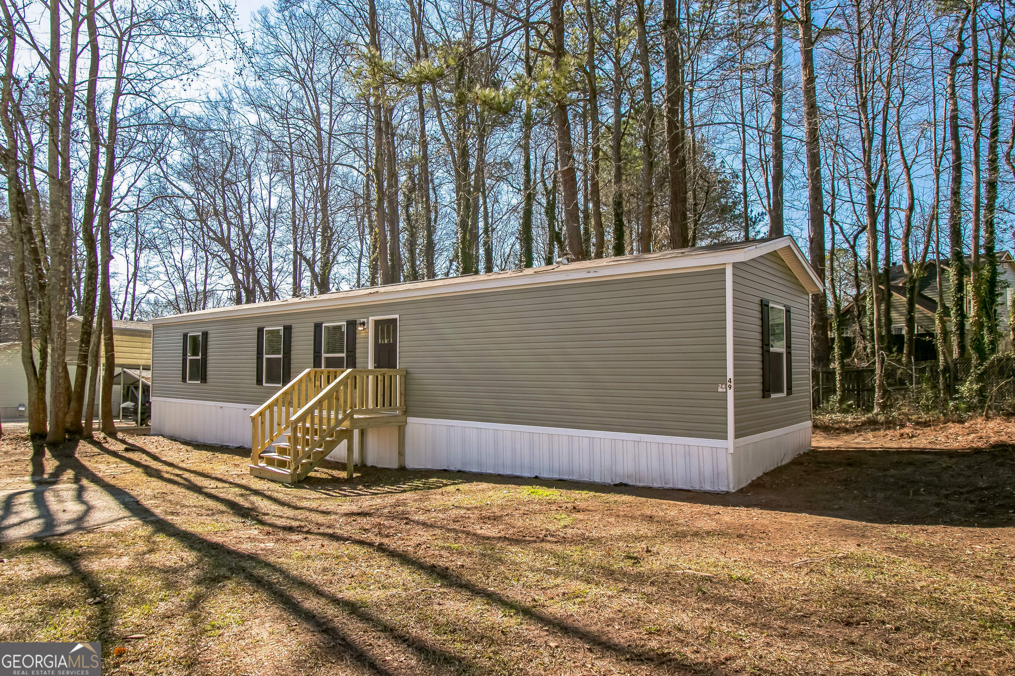 a view of a house with backyard and trees