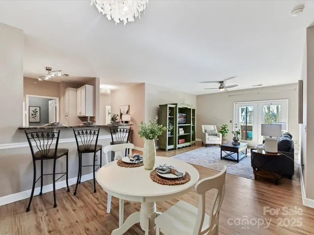 a living room with furniture a dining table and a large window