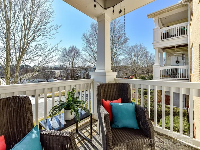 a balcony with wooden floor and outdoor seating