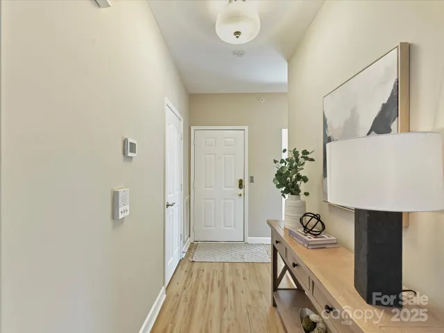 a view of hallway with furniture and wooden floor