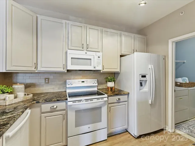 a kitchen with white cabinets and white appliances