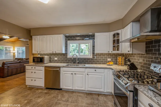 a kitchen with stainless steel appliances granite countertop a stove sink and cabinets