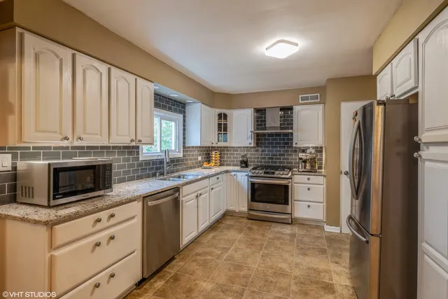 a kitchen with white cabinets and stainless steel appliances
