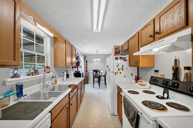 a kitchen with a stove a refrigerator and a sink