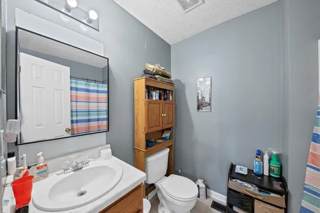 a bathroom with a toilet a sink and a mirror