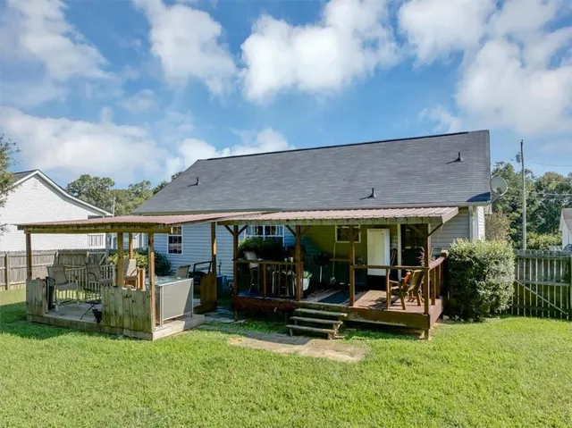 a view of a house with backyard porch and sitting area
