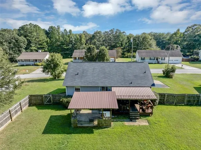 an aerial view of a house with a garden and lake view