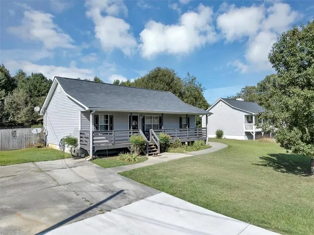 a view of a house with backyard and sitting area