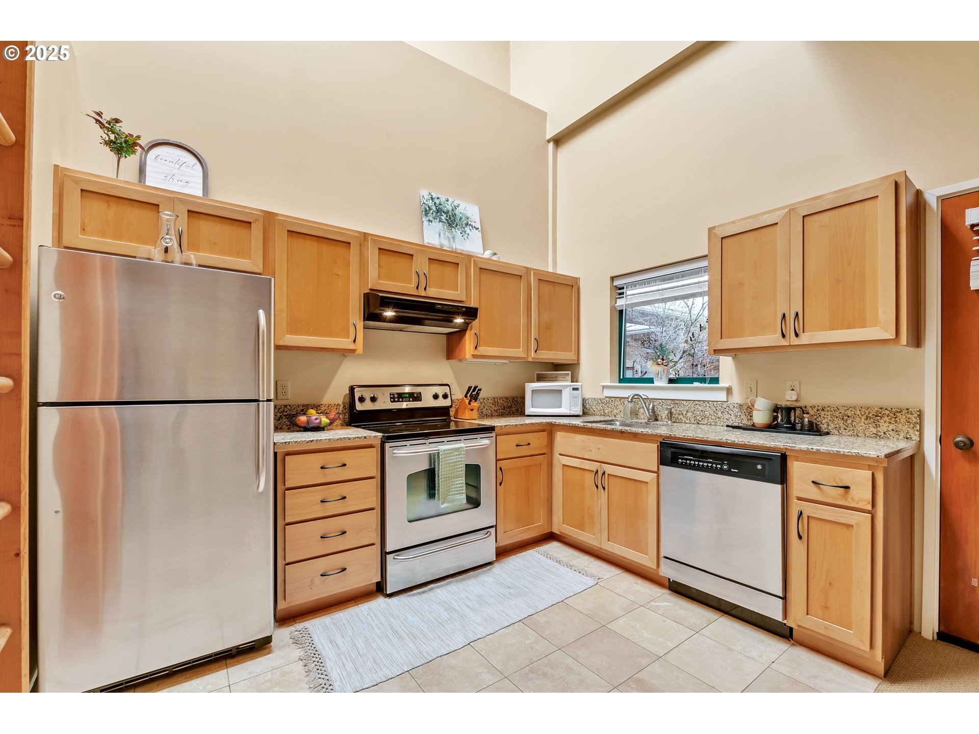 650 West 12th Avenue, Unit 211 Eugene, OR 97402 - Photo 13 of 39 a kitchen with stainless steel appliances granite countertop a refrigerator sink stove microwave and cabinets