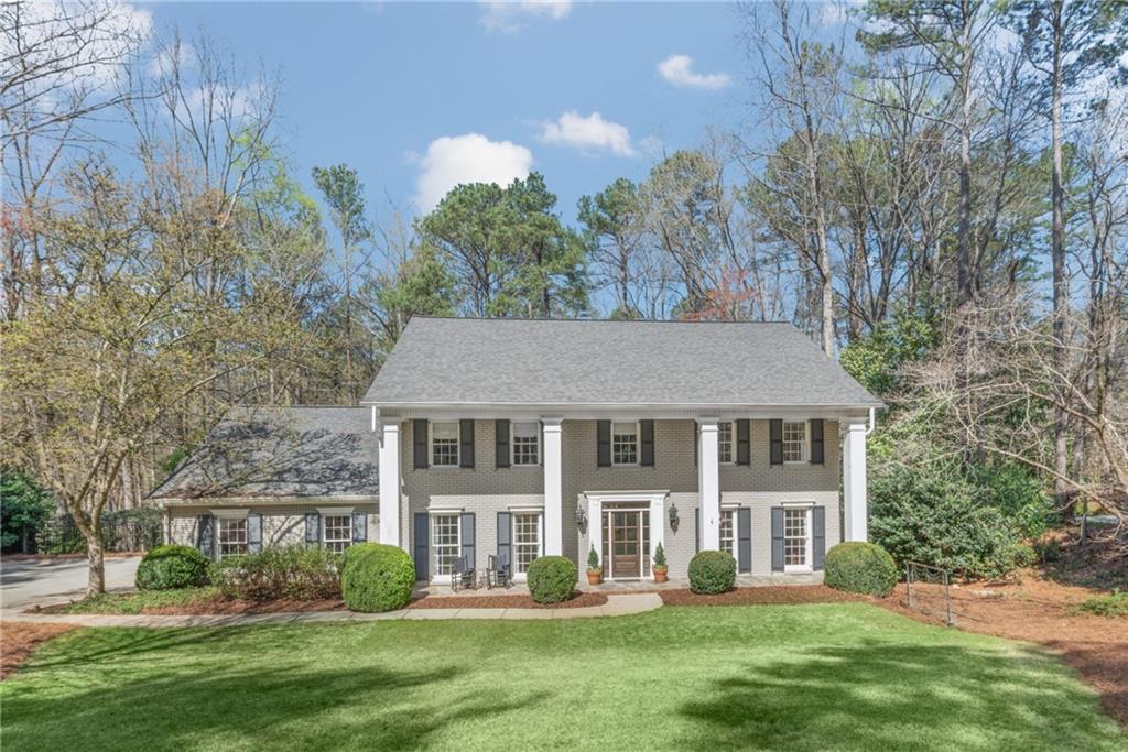 925 Riverside Trace Northwest Atlanta, GA 30328 - Photo 1 of 1 a front view of a house with a garden and trees