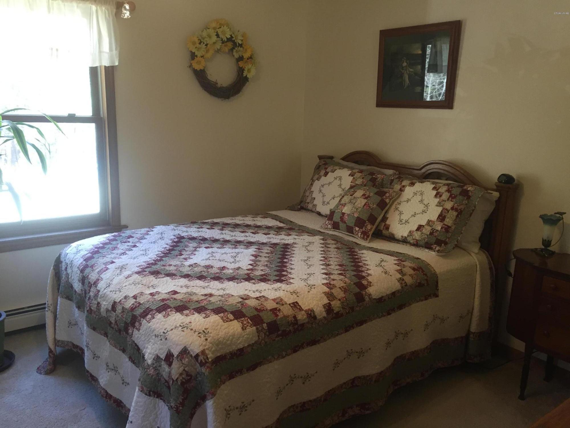 117 Clark Wright Road Middlefield, MA 01050 - Photo 13 of 22 a bed sitting in a bedroom next to a window