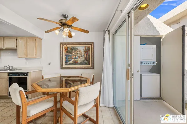 a kitchen with stainless steel appliances granite countertop a stove a refrigerator a kitchen island a table and chairs with wooden floor