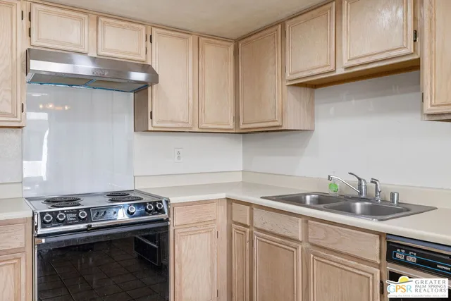 a kitchen with stainless steel appliances granite countertop a sink and a stove