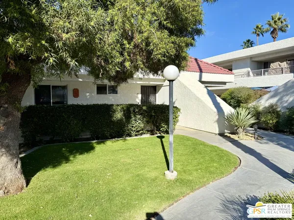 a view of a house with fountain in the background