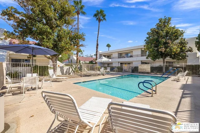 a view of a patio with a table and chairs under an umbrella