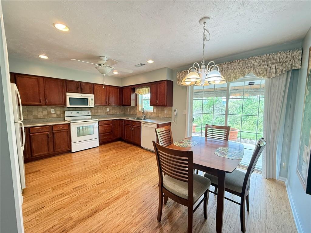 411 Chestnut Lane Apollo, PA 15613 - Photo 5 of 38 a kitchen with stainless steel appliances granite countertop a stove top oven a sink dishwasher a dining table and chairs with wooden floor