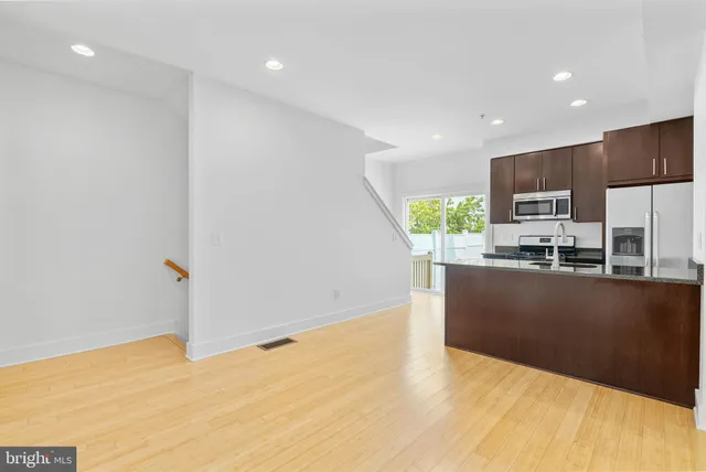 a kitchen with stainless steel appliances a refrigerator sink and microwave